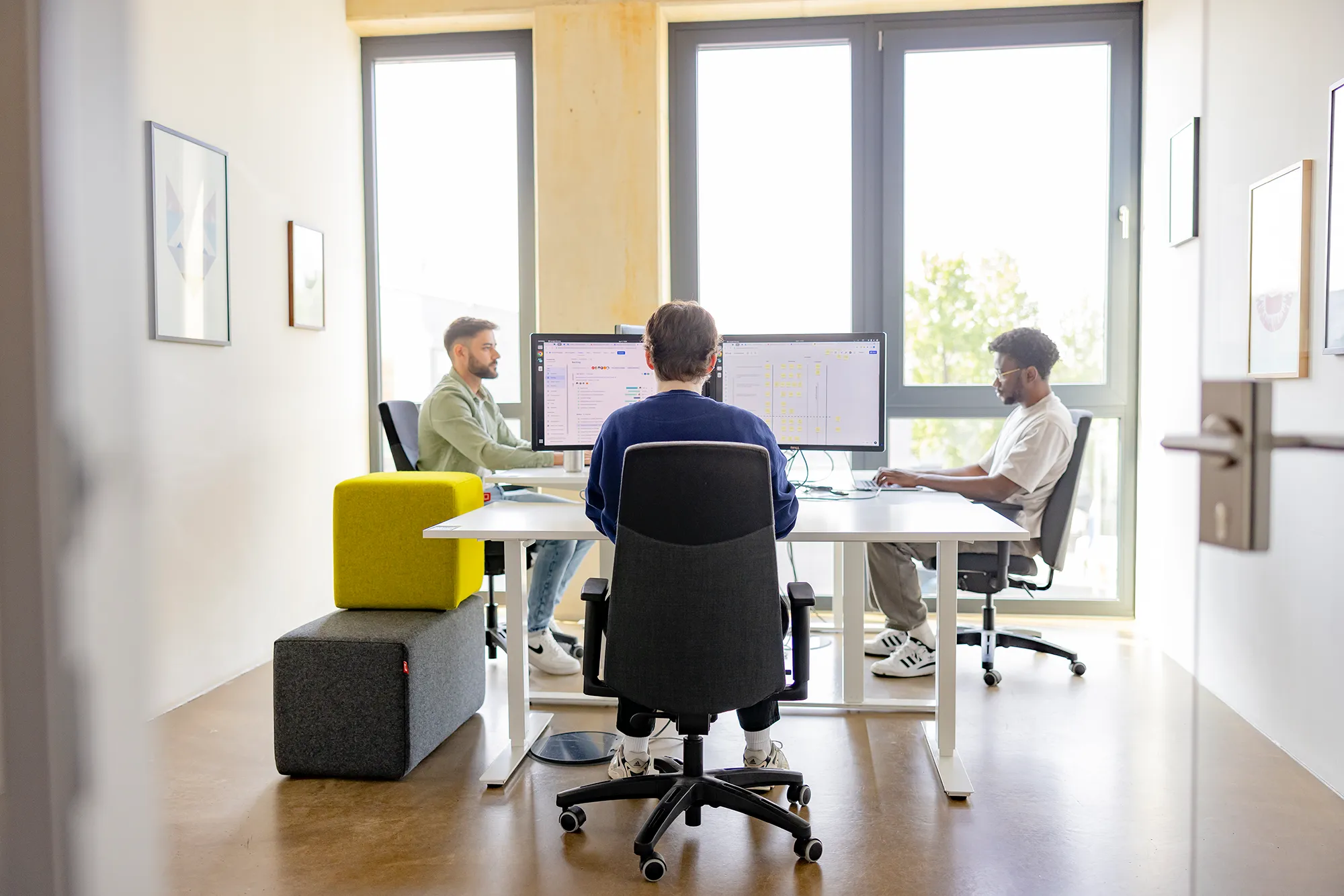Ein Blick in unser Teambüro mit drei Mitarbeitenden bei kernpunkt.