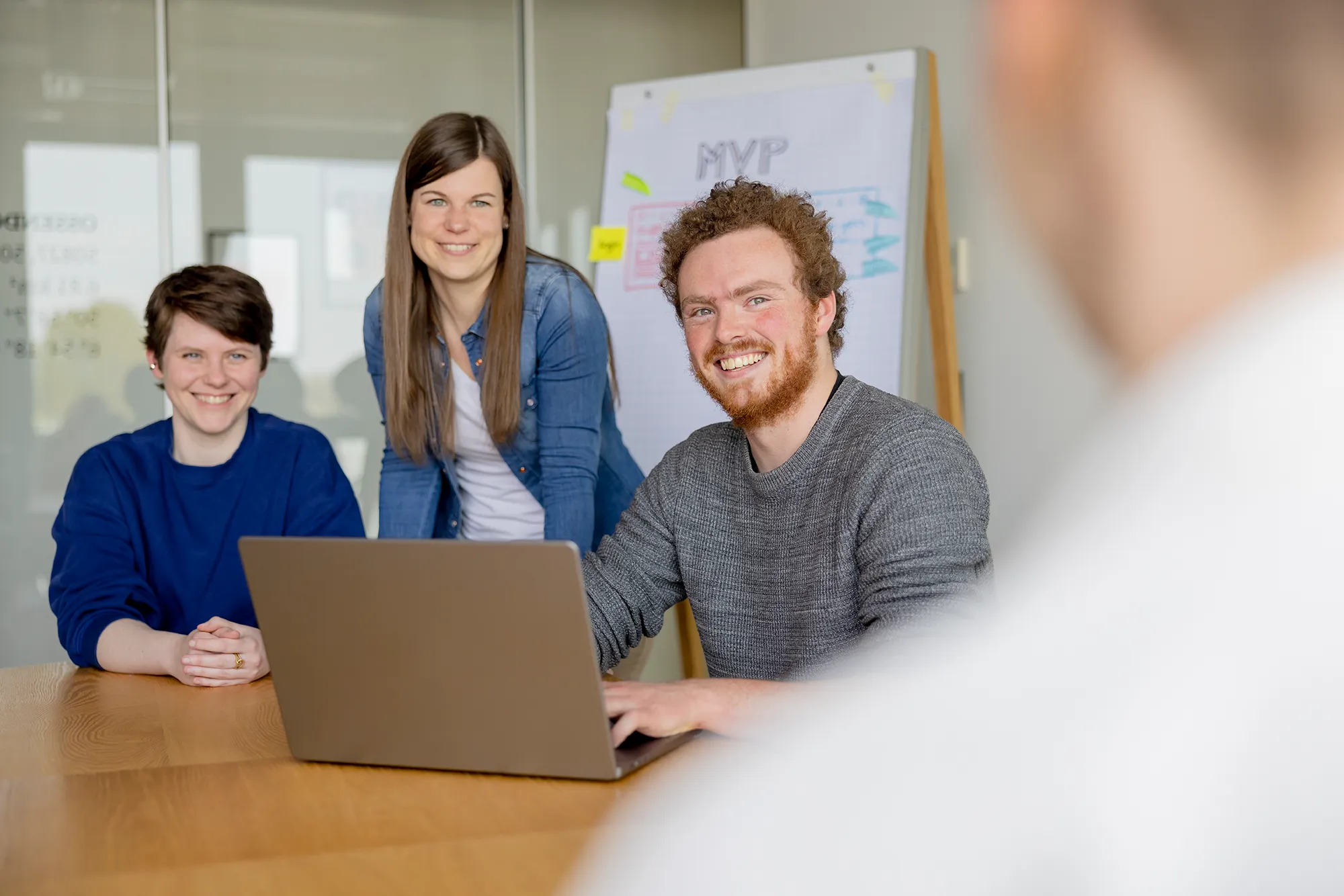 Drei Fachkräfte diskutieren unsere Kundenprojekte und entwickeln Strategien für einen MVP.