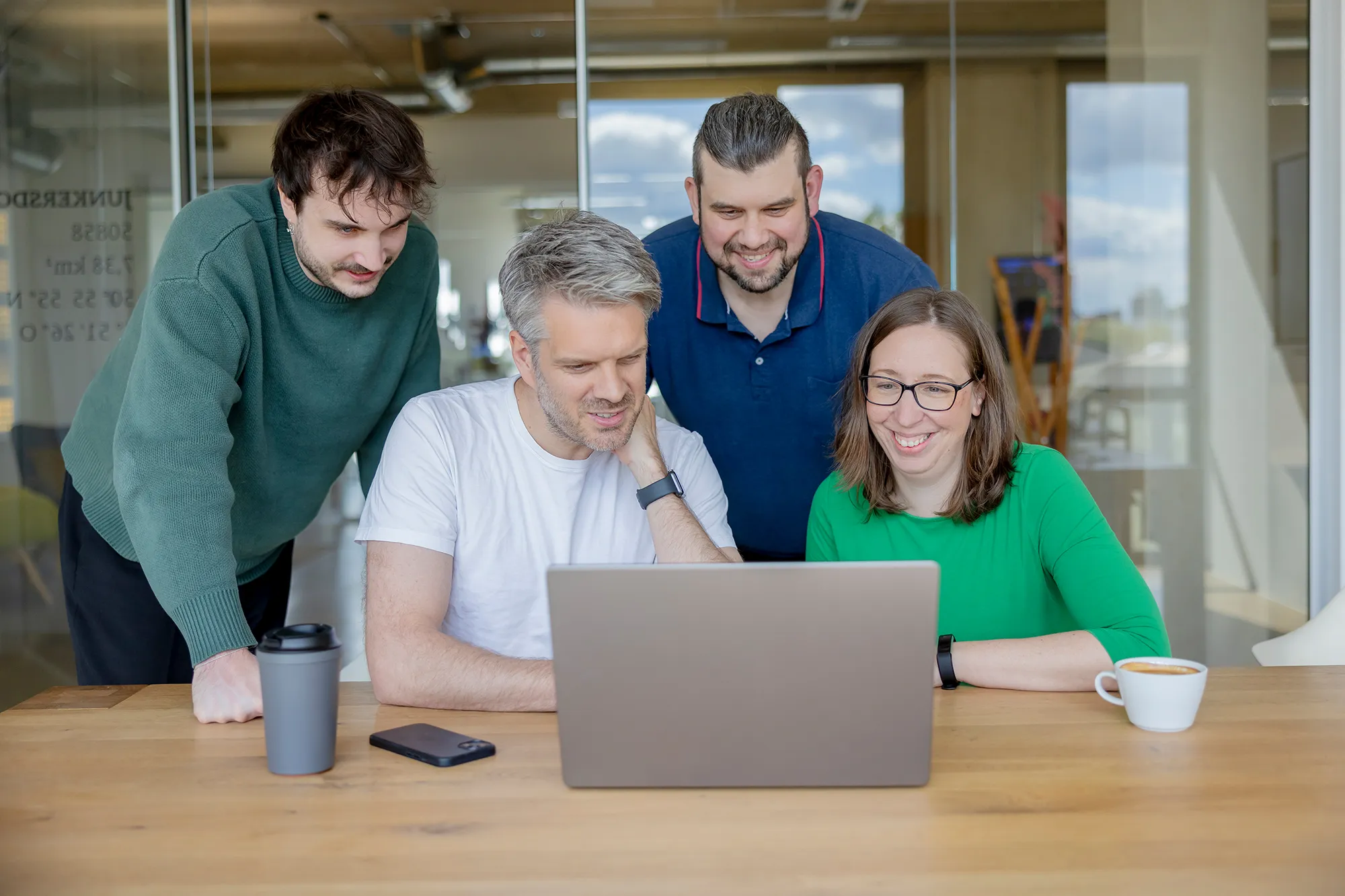Das kernpunkt Team schaut sich die Ergebnisse eines Kundenprojekts im Meetingraum an.
