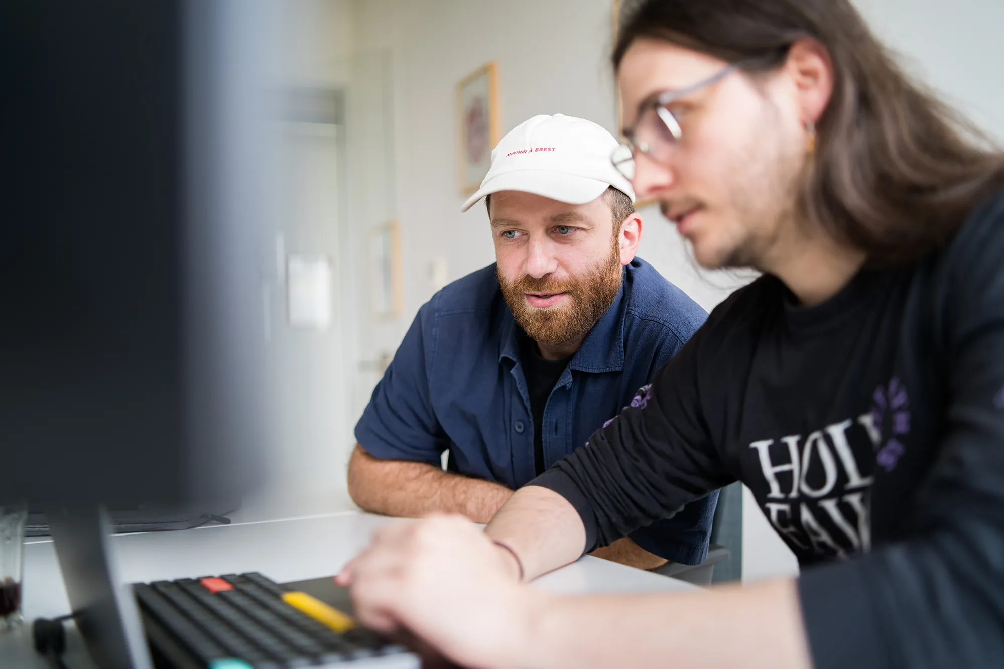 Zwei Mitarbeitende von kernpunkt schauen sich etwas auf dem Monitor an.