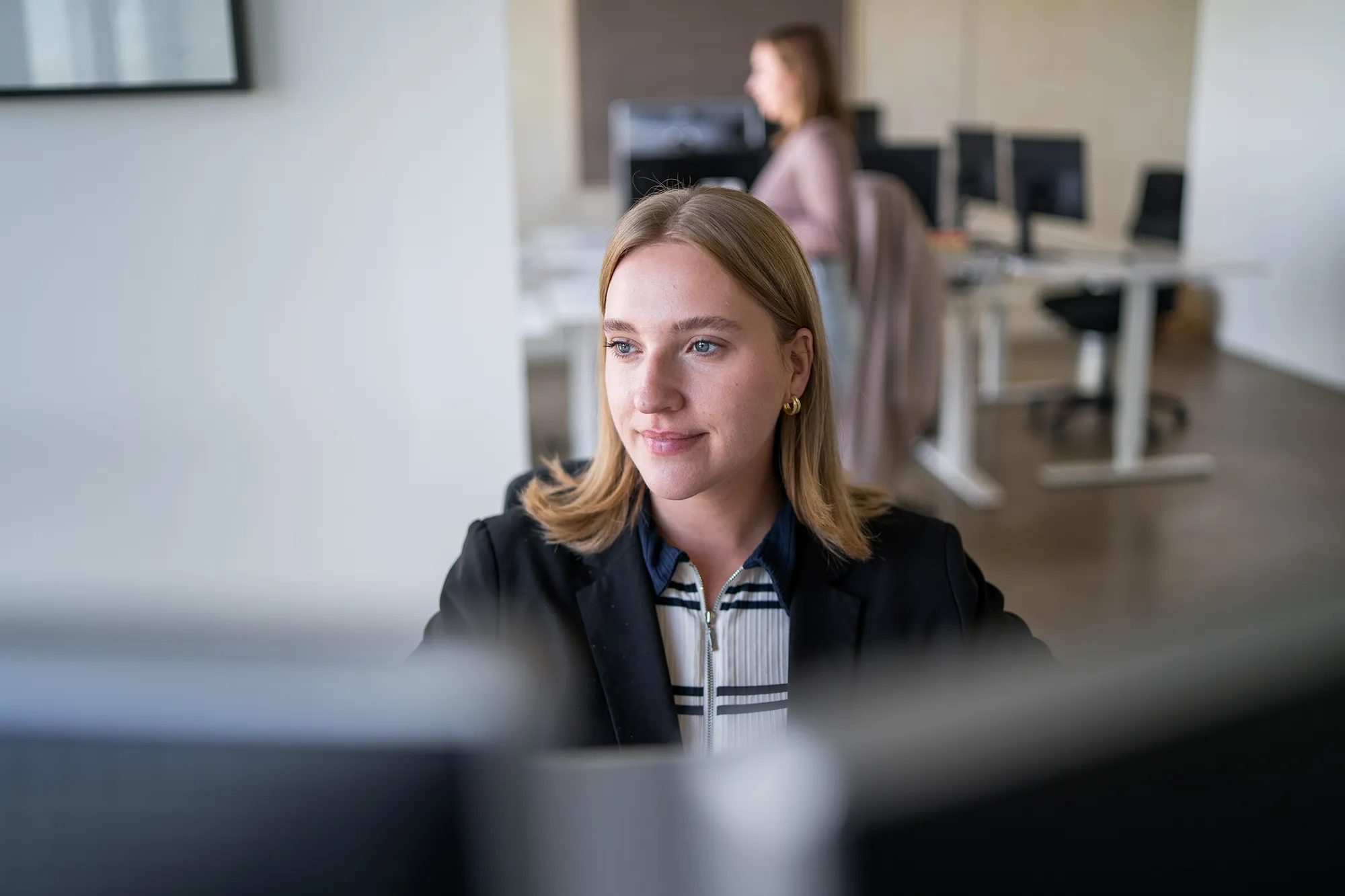 Mitarbeitende sitzt am PC im Büro