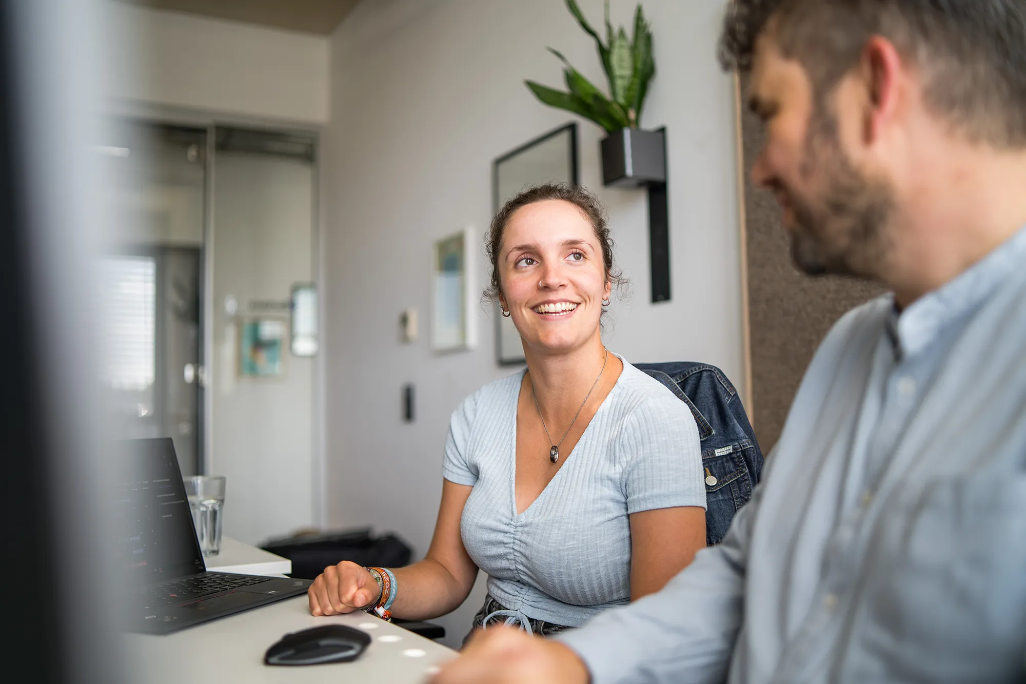 Mitarbeiterin hört ihrem Kollegen zu.