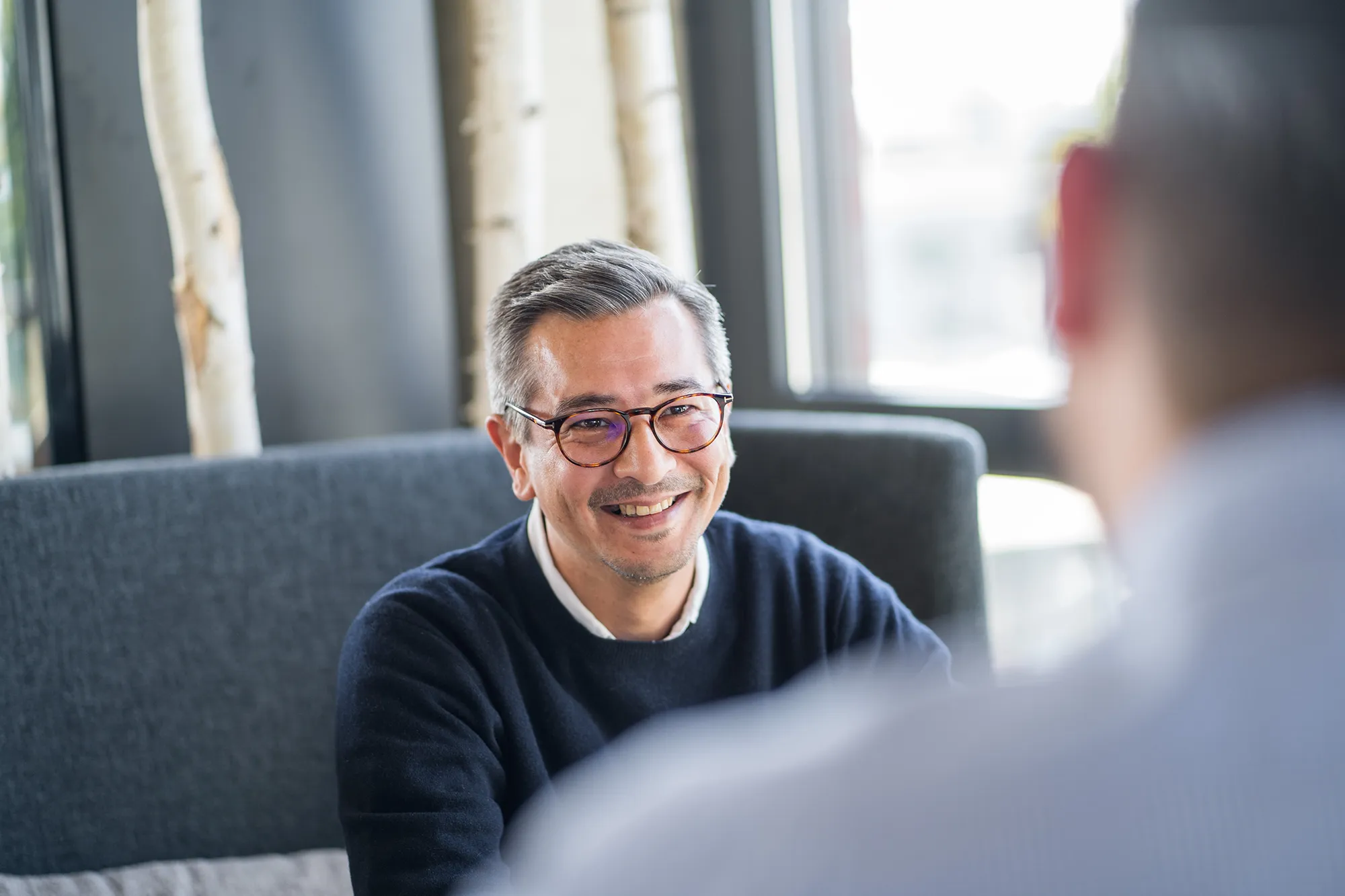 Mitarbeiter lächelt Gesprächspartner an.