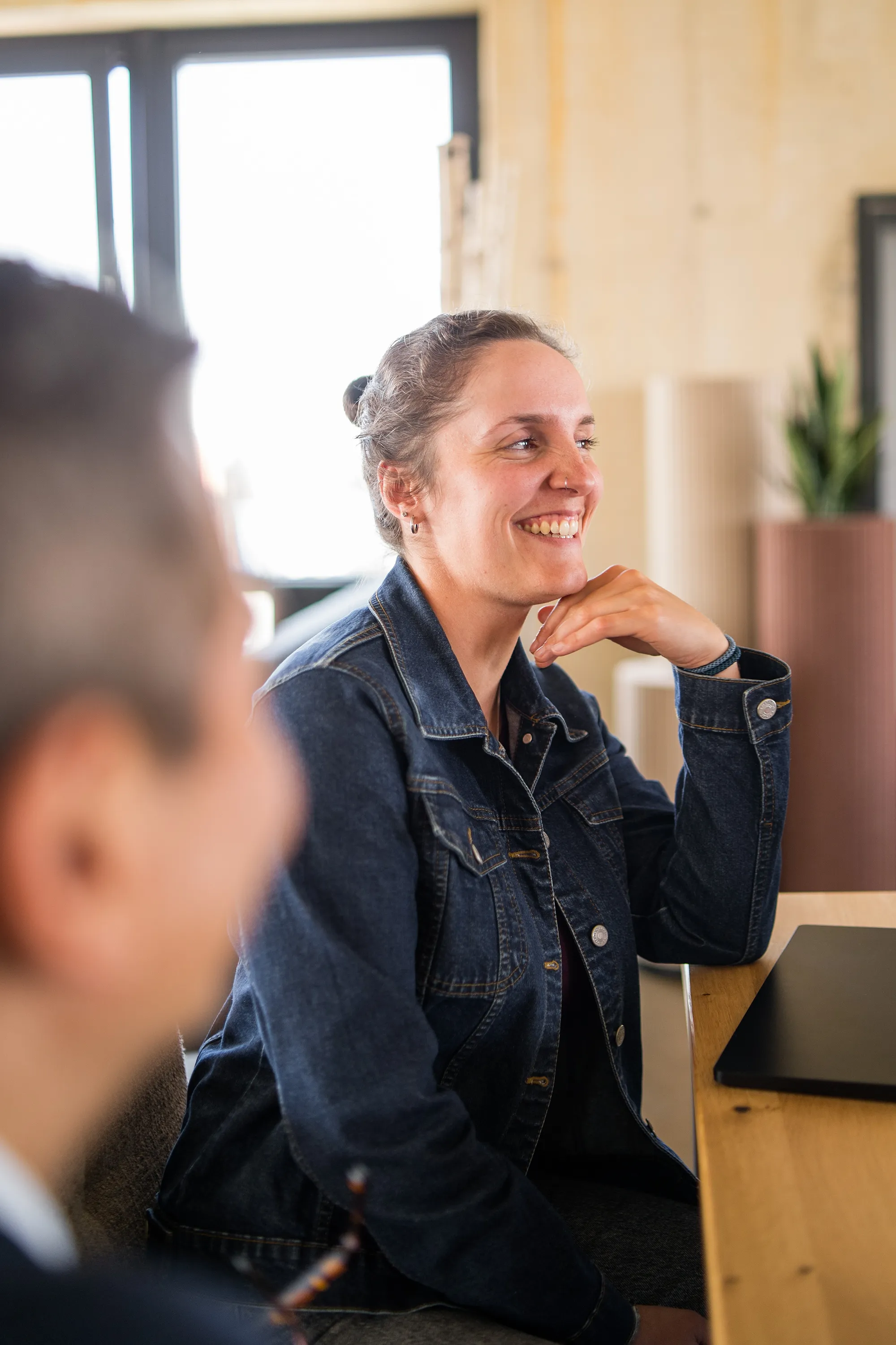 Mitarbeiterin lächelt im Gespräch.