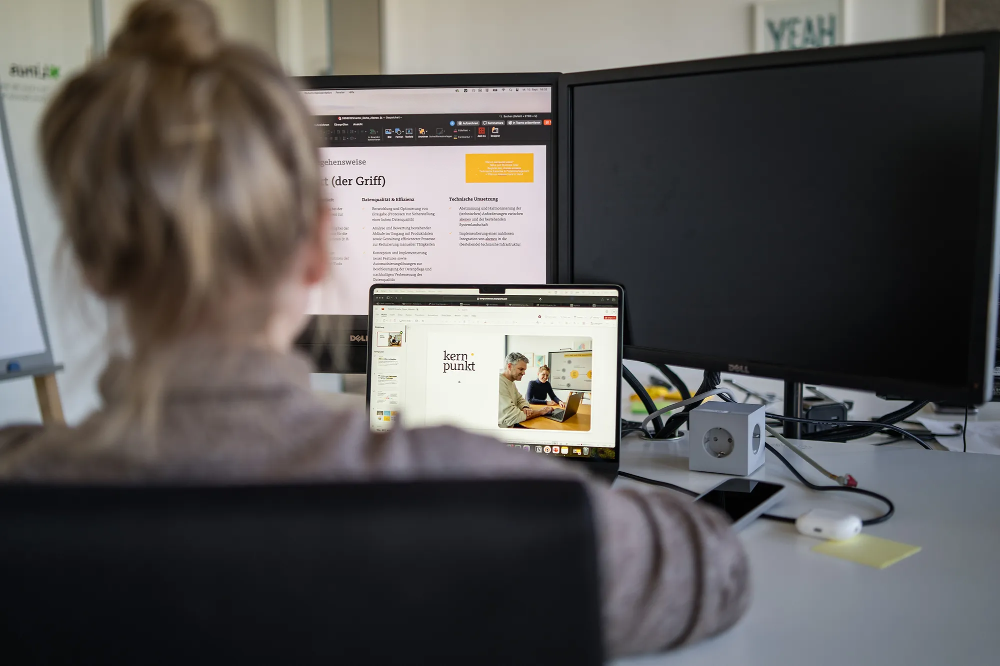 Der Blick über die Schulter einer Mitarbeitenden von kernpunkt auf den Laptop.