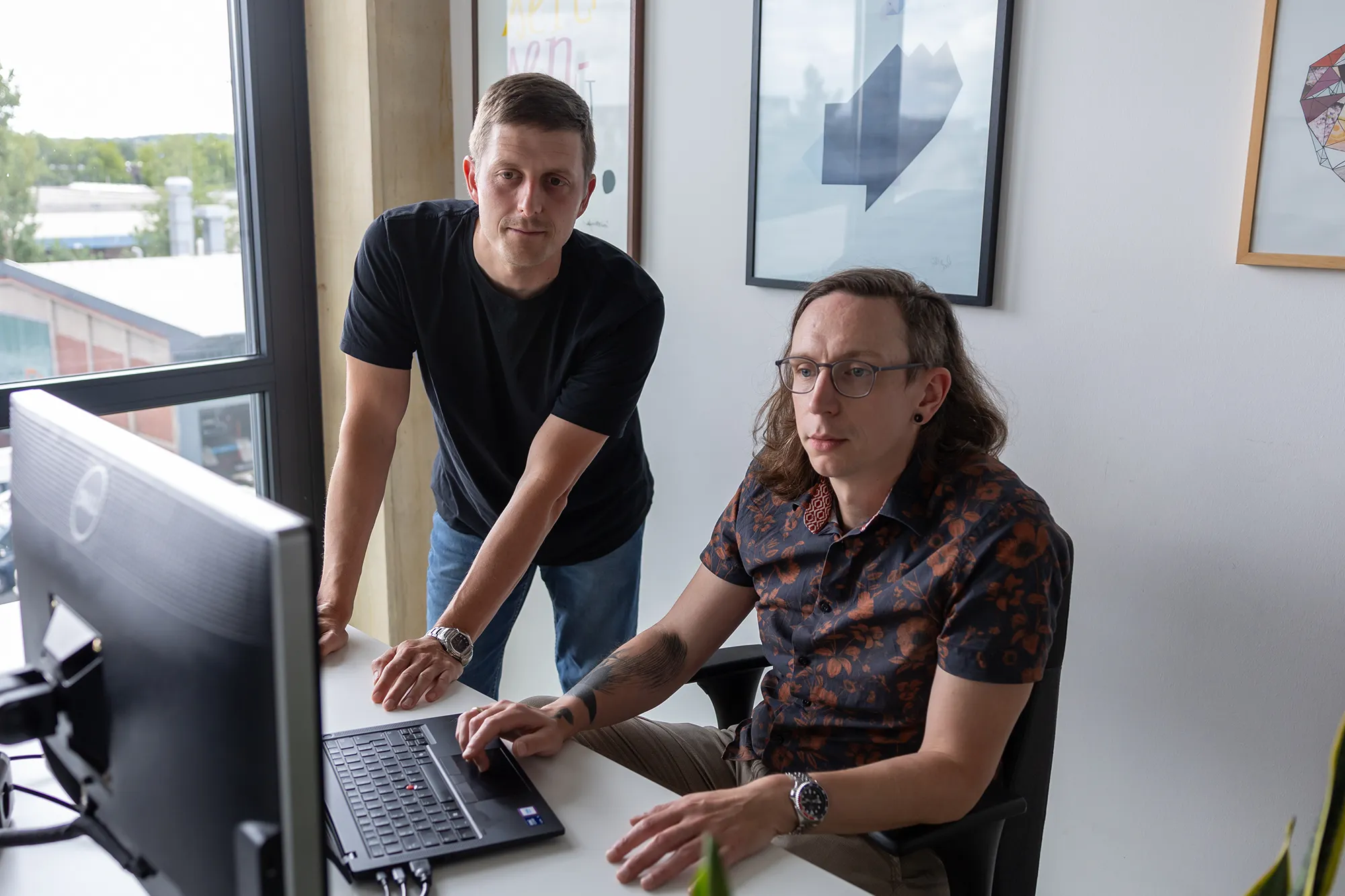 Unsere beiden Solution Architects besprechen etwas am Monitor.