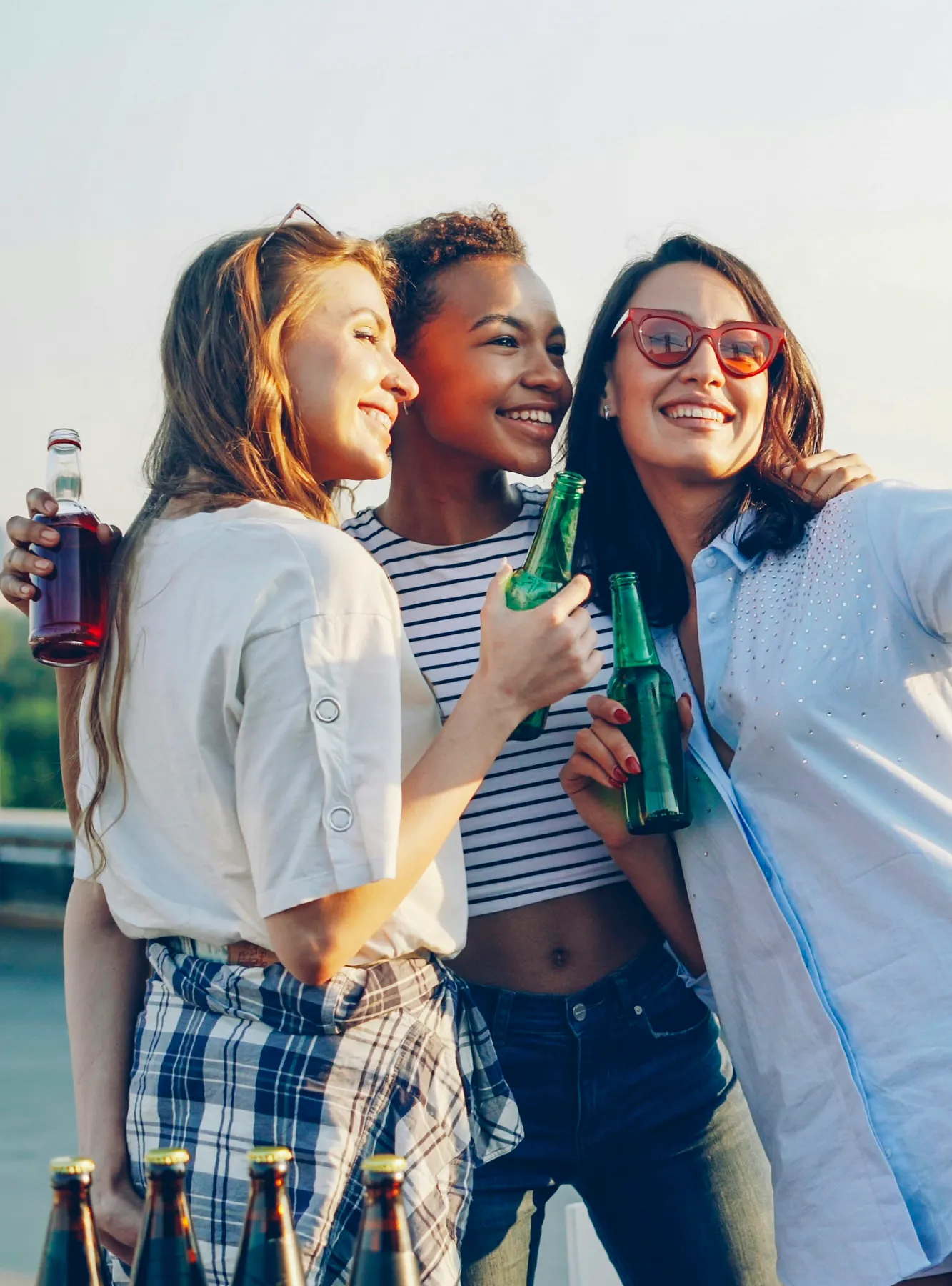 Drei Frauen trinken im Sonnenschein