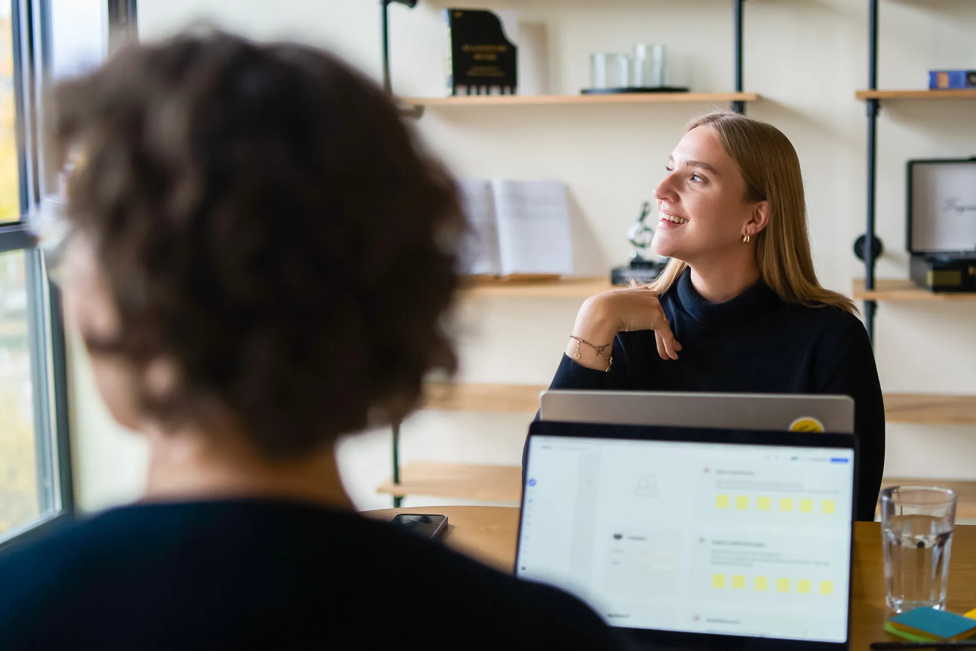 Zwei UX-Designerinnen schauen sich eine Präsentation an