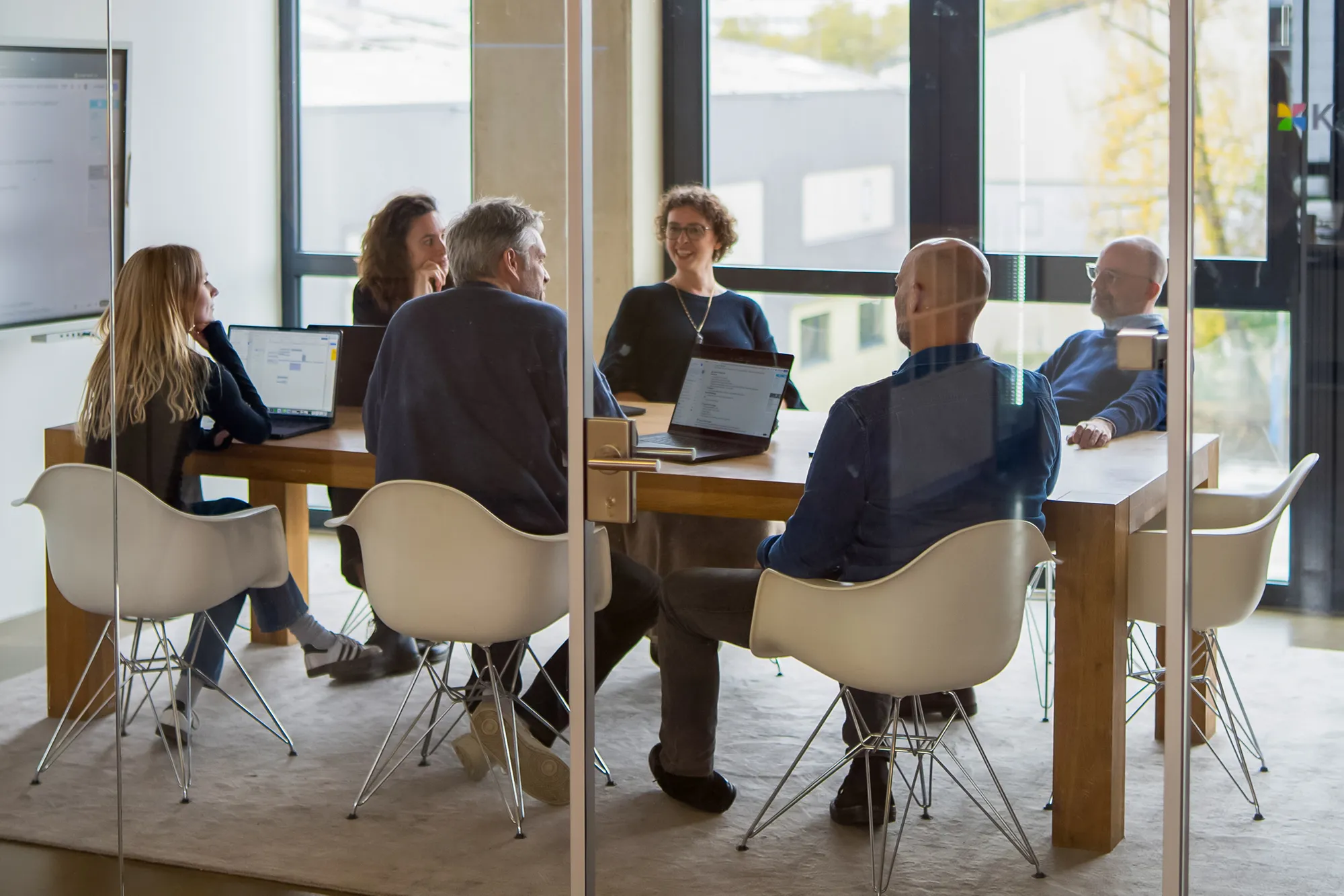 Sechs Personen unterhalten sich im Team-Meeting