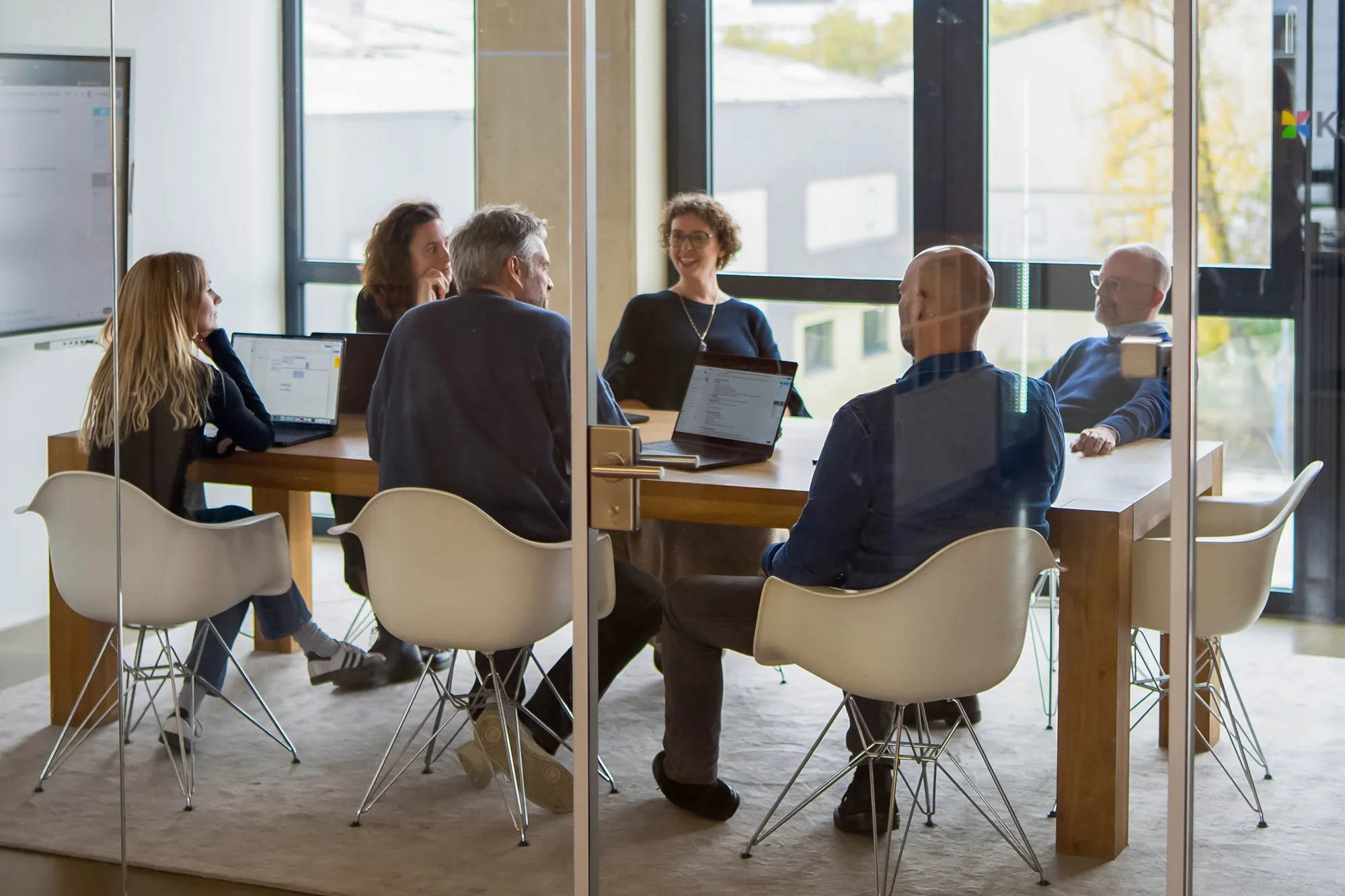 Das Team von kernpunkt sitzt zusammen und bespricht sich im Meetingraum.