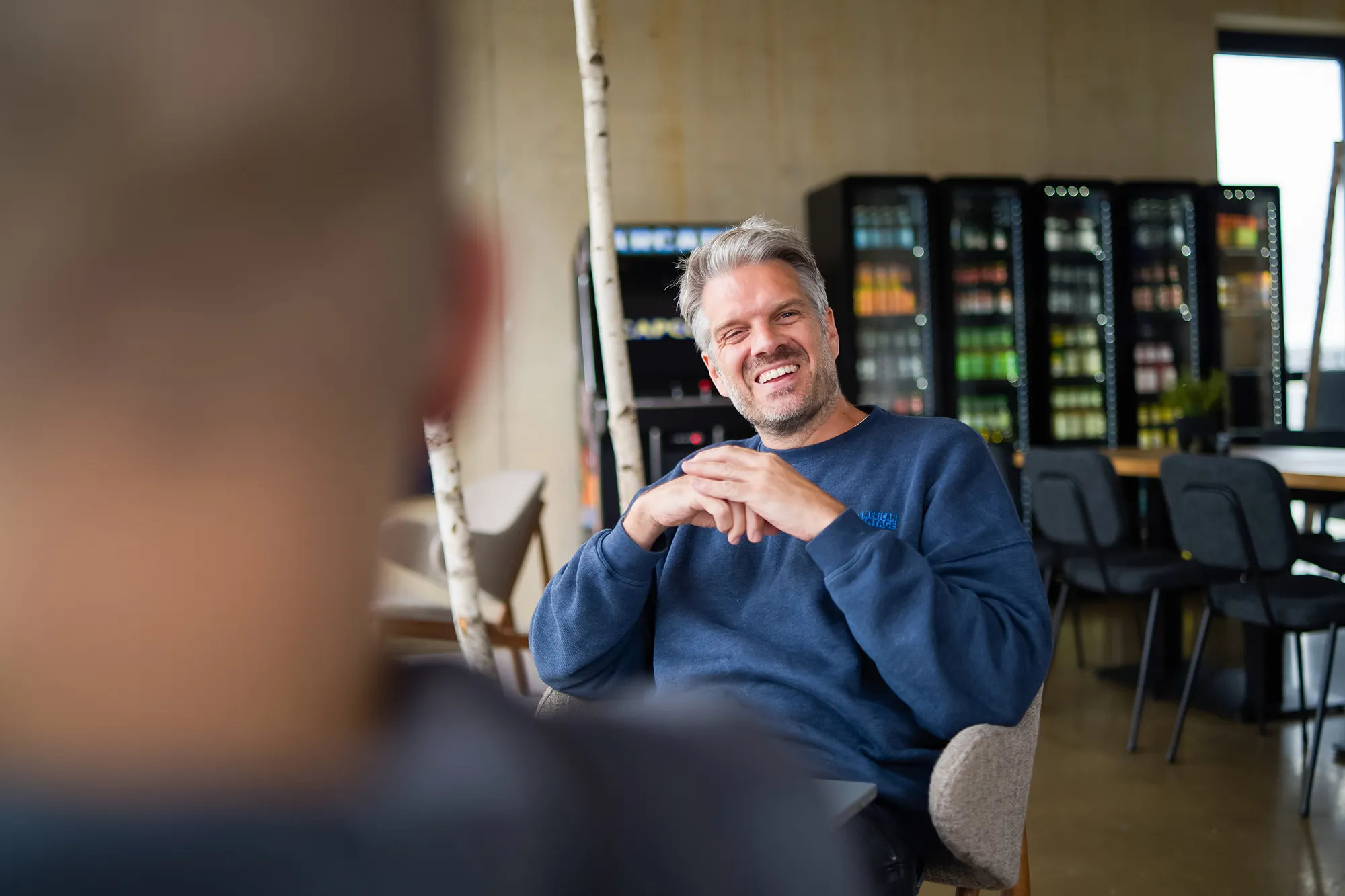 Zwei Kollegen sitzen sich gegenüber und lachen