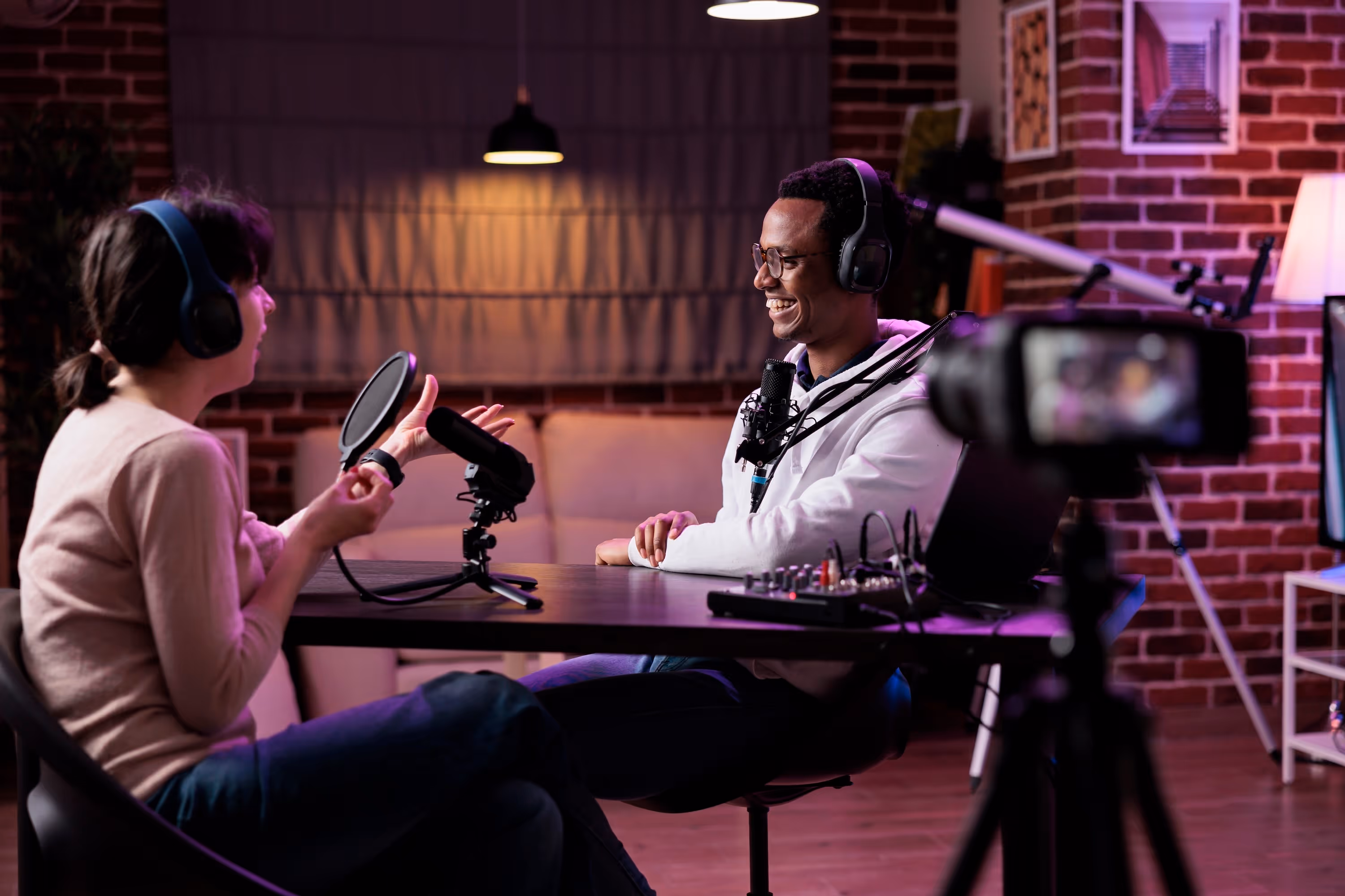 2 people laughing and chatting in a podcast interview