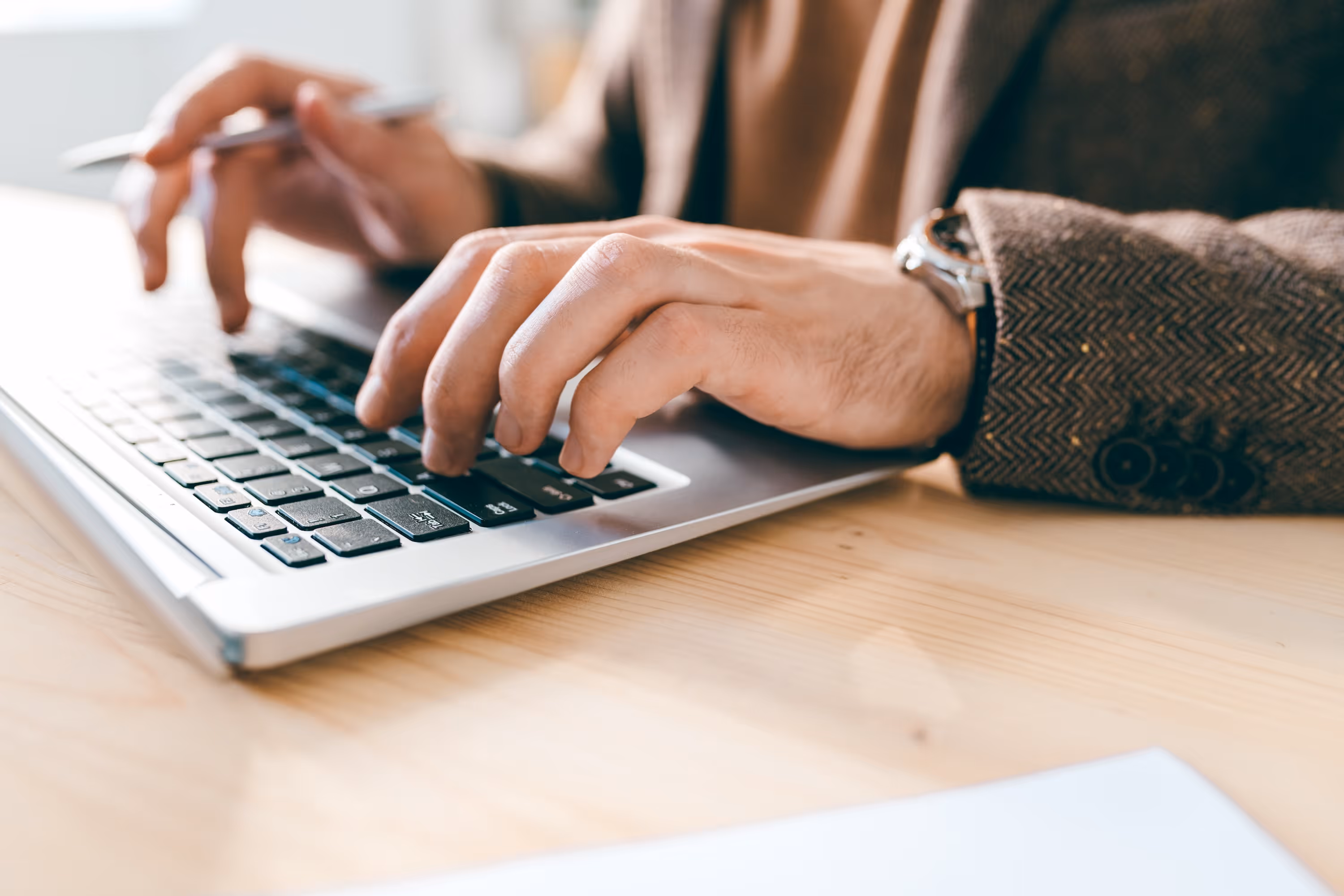 Close-up of hands typing on a laptop keyboard