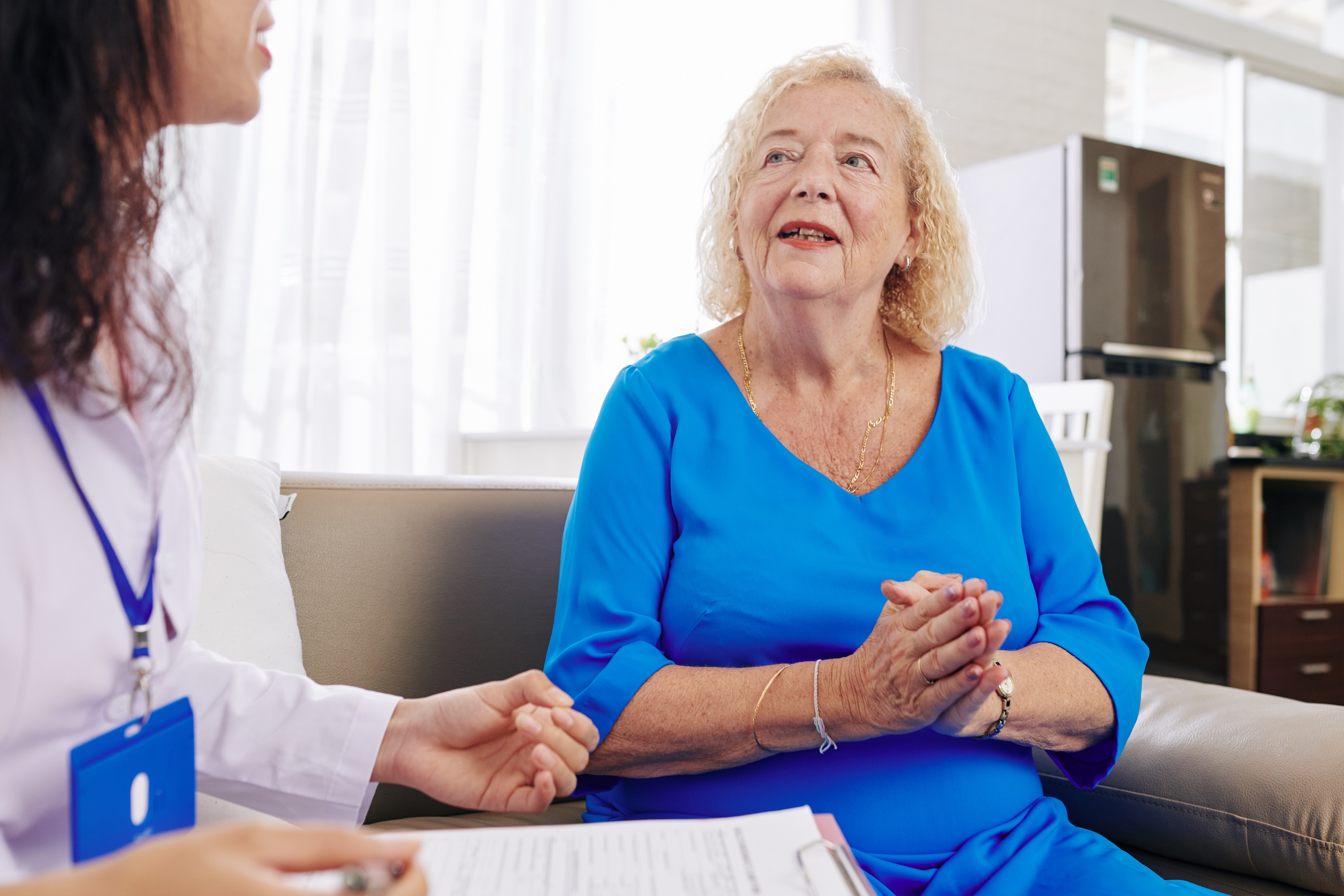 Woman sitting on sofa and talking to a doctor