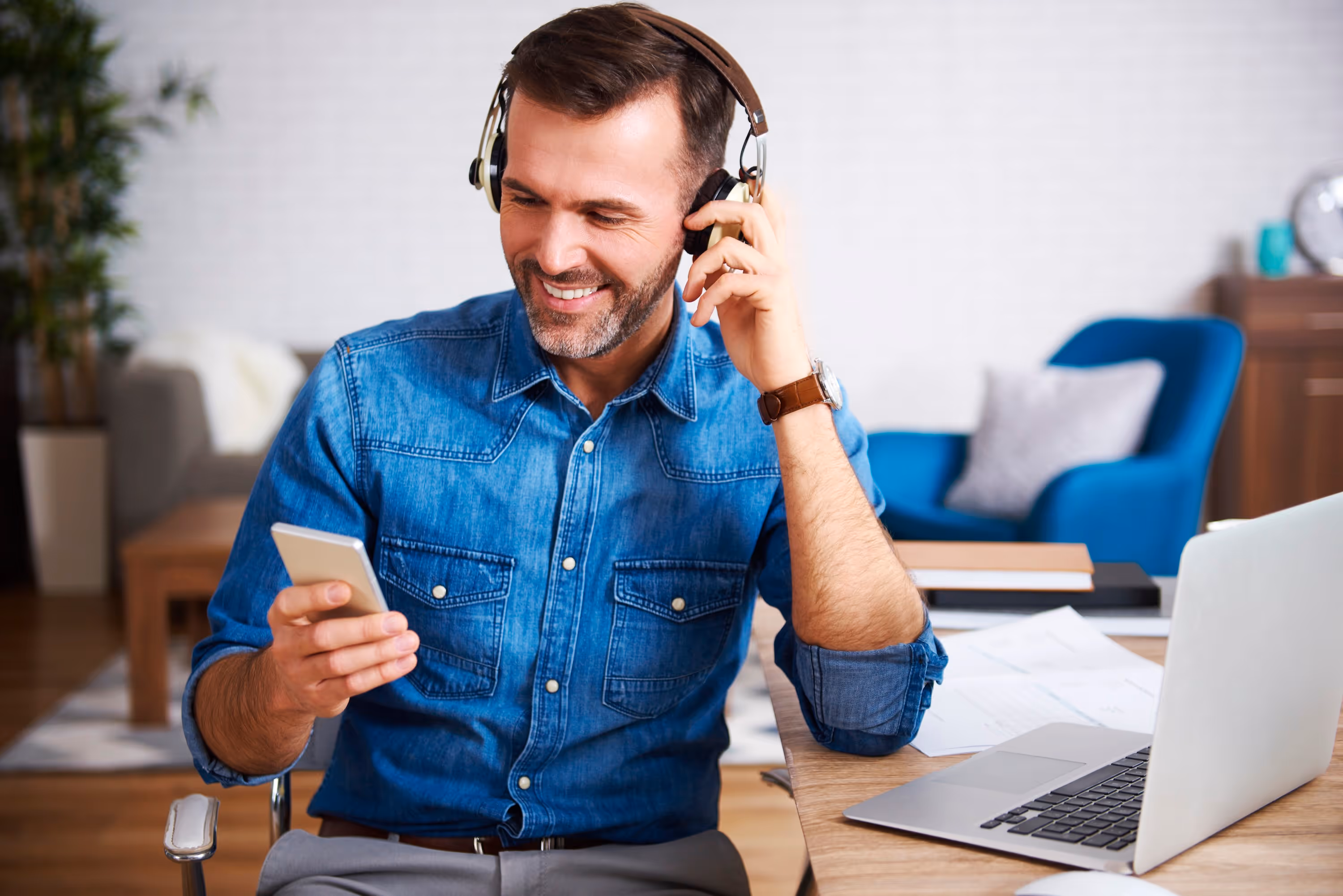 Man wearing headphones smiling looking at his phone
