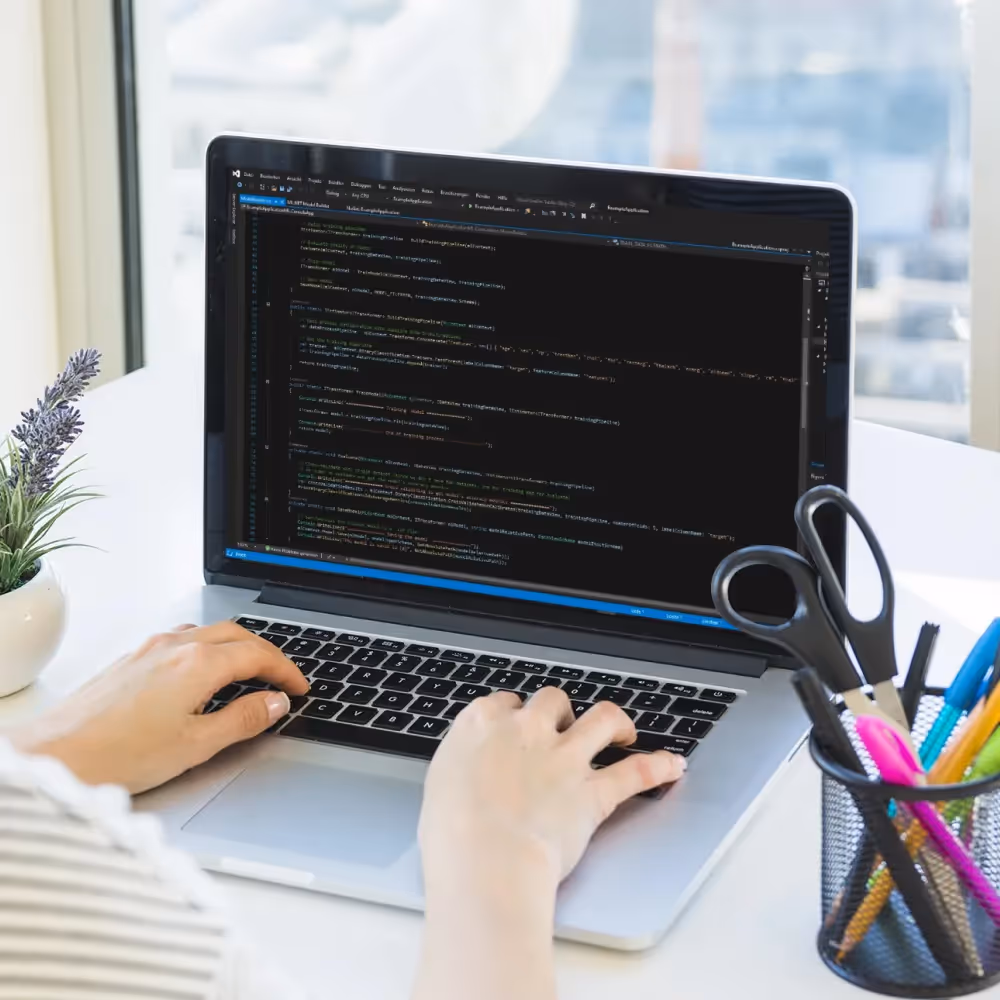 Individual focused on a laptop, representing WhizzBridge's initiatives for operational efficiency and tech enhancements.