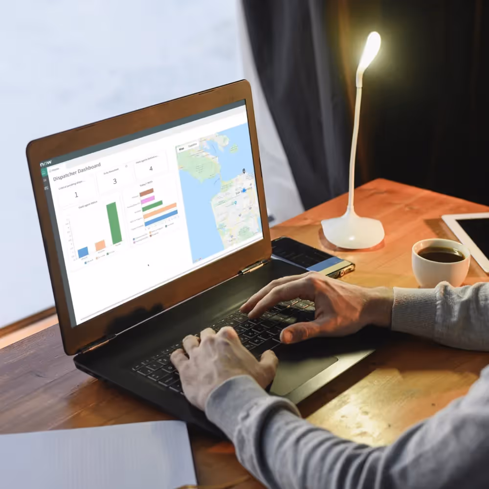 A man is focused on a laptop showing a map, highlighting WhizzBridge's automated task assignments and technician routing system.