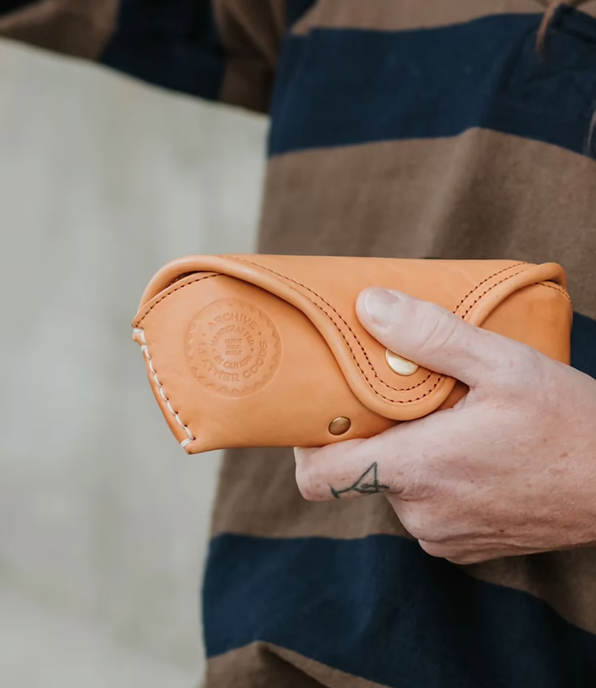 Archive Leather badge stamped into beige leather glasses case