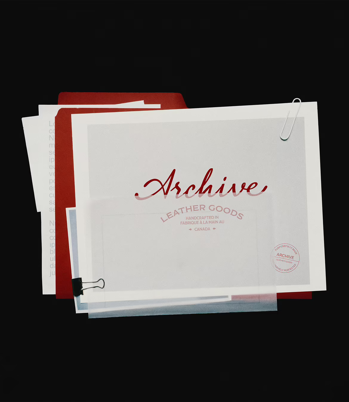 Stack of papers and folders with a white sheet on top featuring the word 'Archive' in red cursive and the text 'Leather Goods, Handcrafted in Canada' below, with a paperclip and binder clip attached.