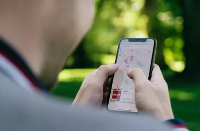 A person in a gray shirt using Apple Maps for navigation.