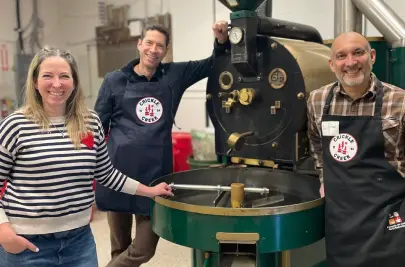 Alejandro Martinez and colleagues of Crickle Creek Coffee pose with their coffee roaster.