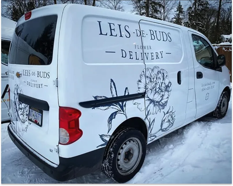 A Leis de Buds branded delivery van parked on a snow-covered street.
