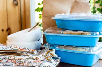 Three Red Apron meals packaged in blue reusable containers.