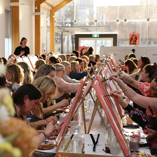 people painting under a marquee
