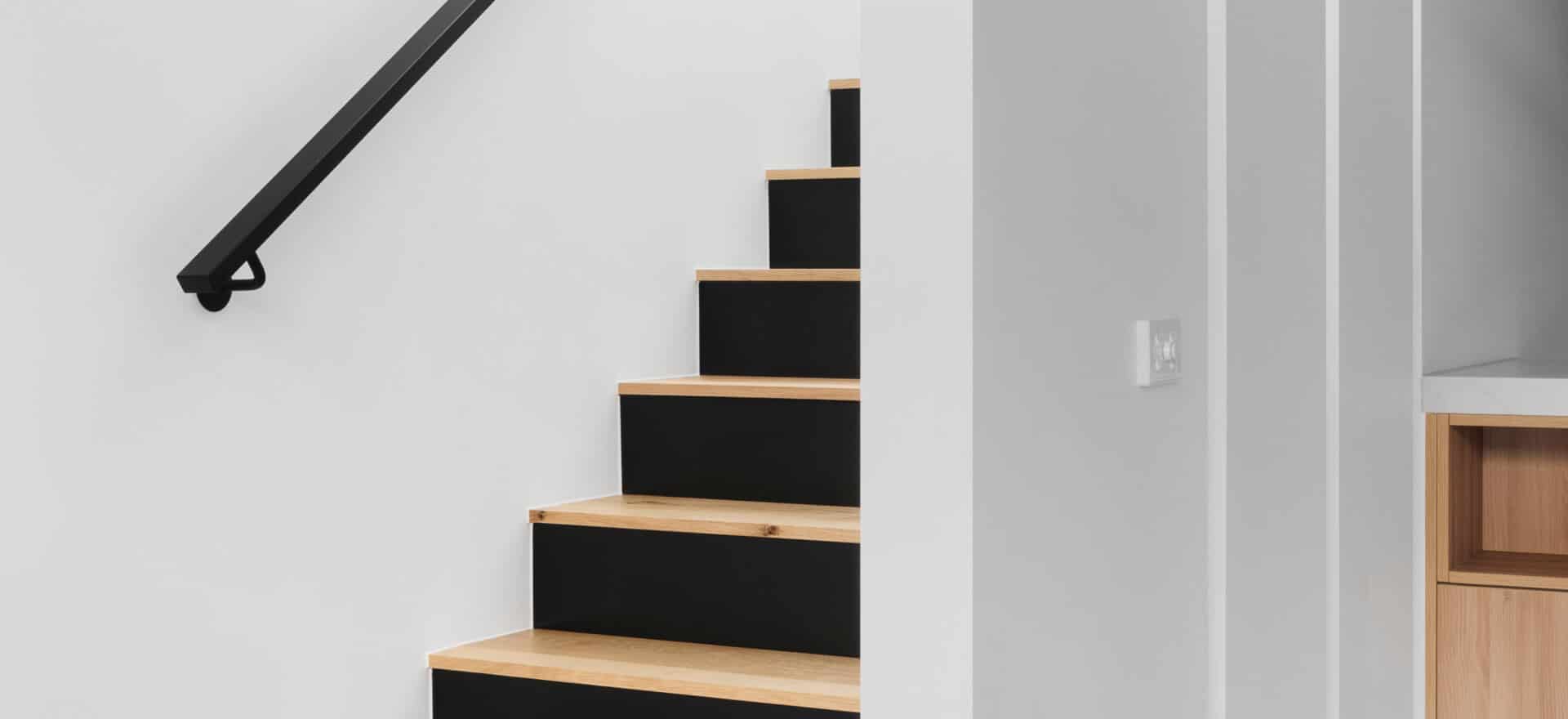 white wooden staircase with stainless steel railings