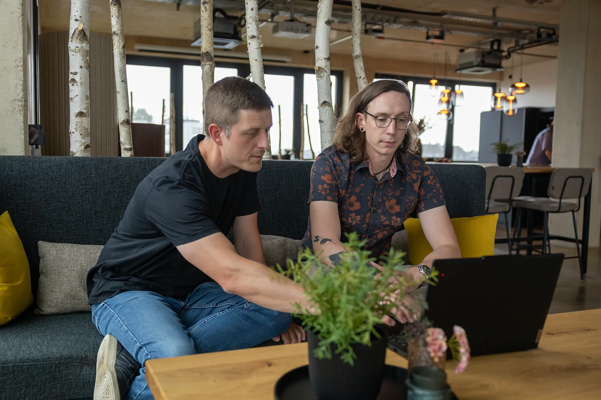 Die beiden Solution Architects von kernpunkt schauen sich Cora von commercetools auf dem Laptop an.