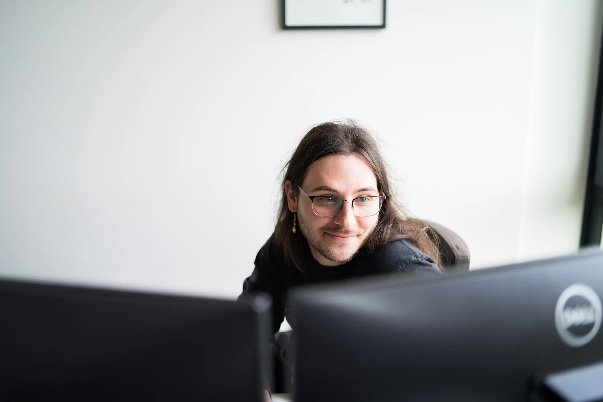 Mitarbeitender beschäftigt sich am Arbeitsplatz mit Mobile Commerce.