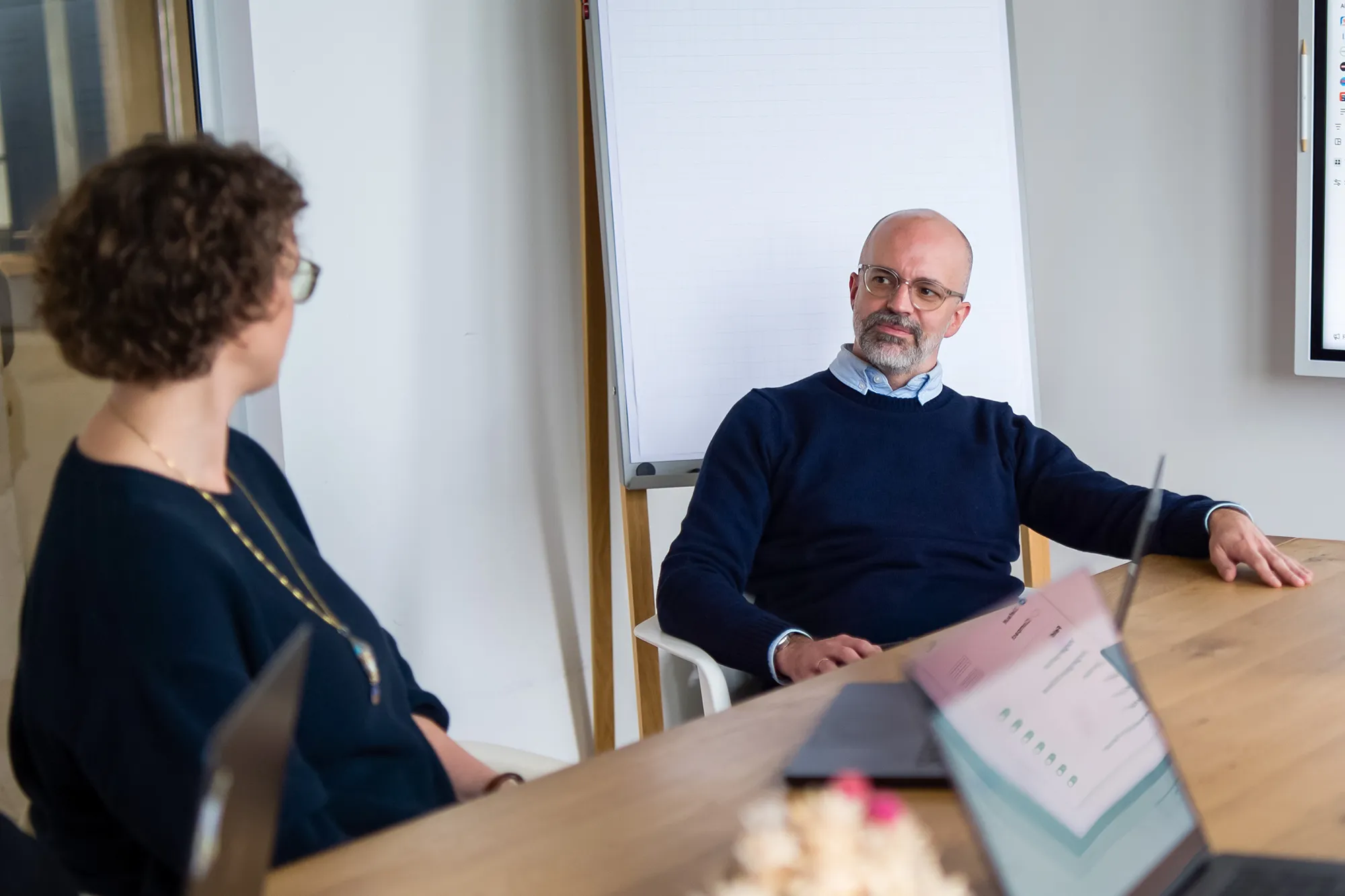Zwei Mitarbeitende unterhalten sich im Meeting-Raum