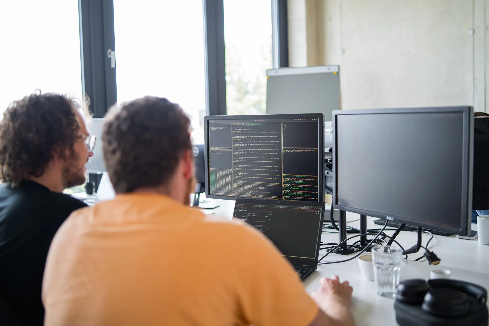 Zwei Mitarbeitende arbeiten am PC im Büro.