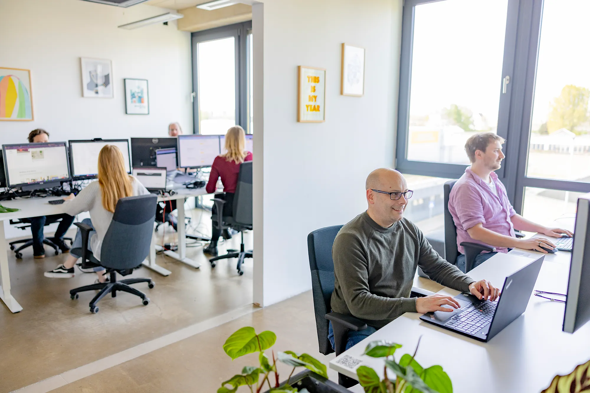 Mitarbeitende sitzen gemeinsam im Büro.