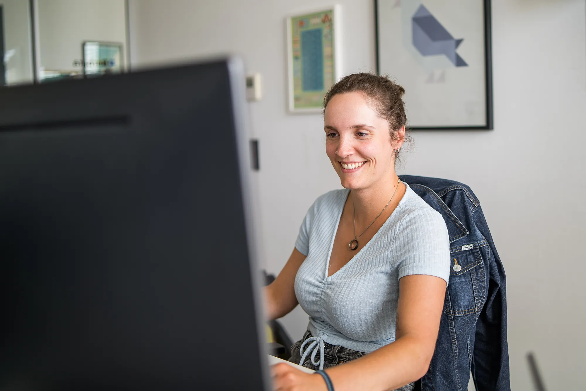 Mitarbeiterin schaut sich am PC die AI-Features verschiedener Technologien an.