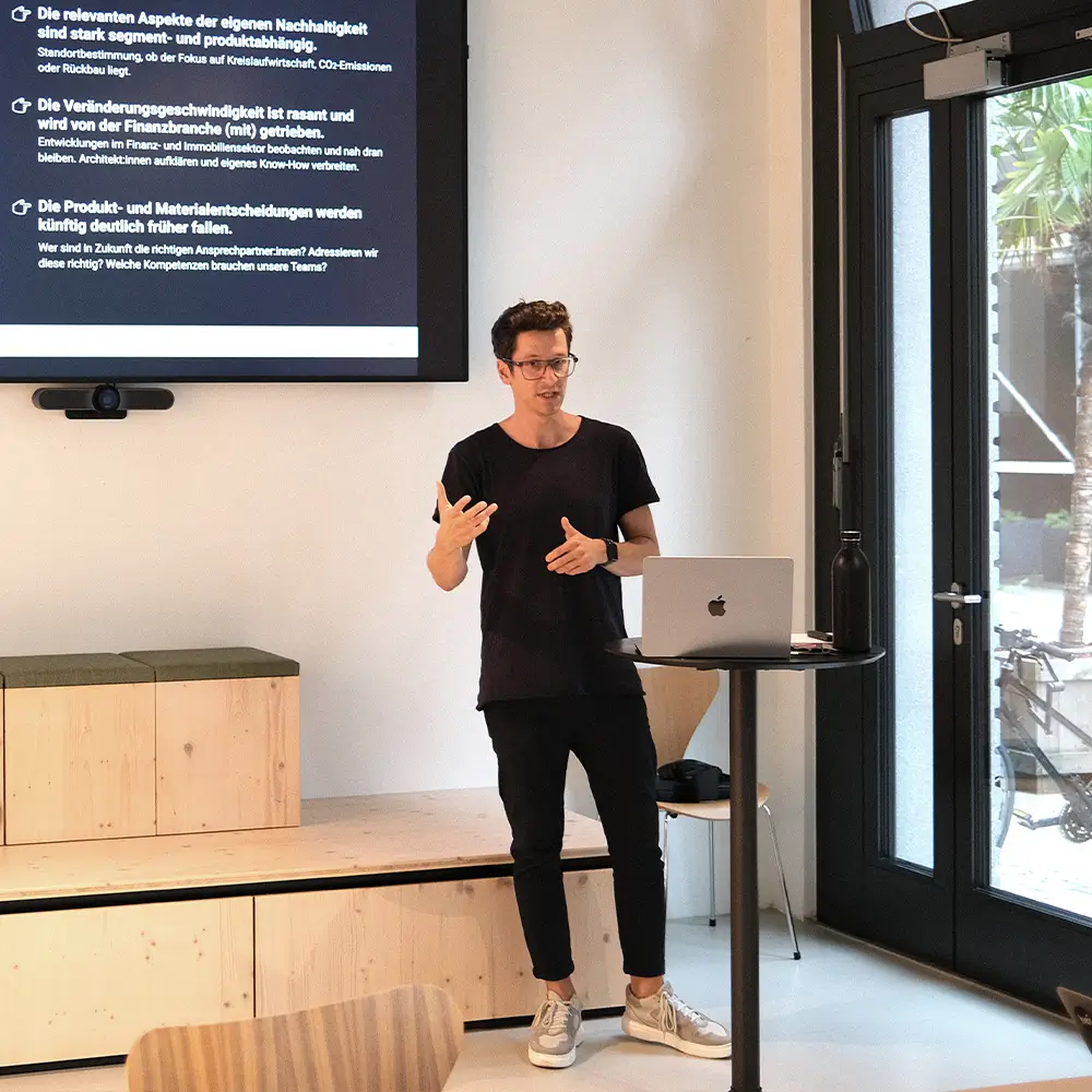 Man gives a presentation in front of a room full of people.