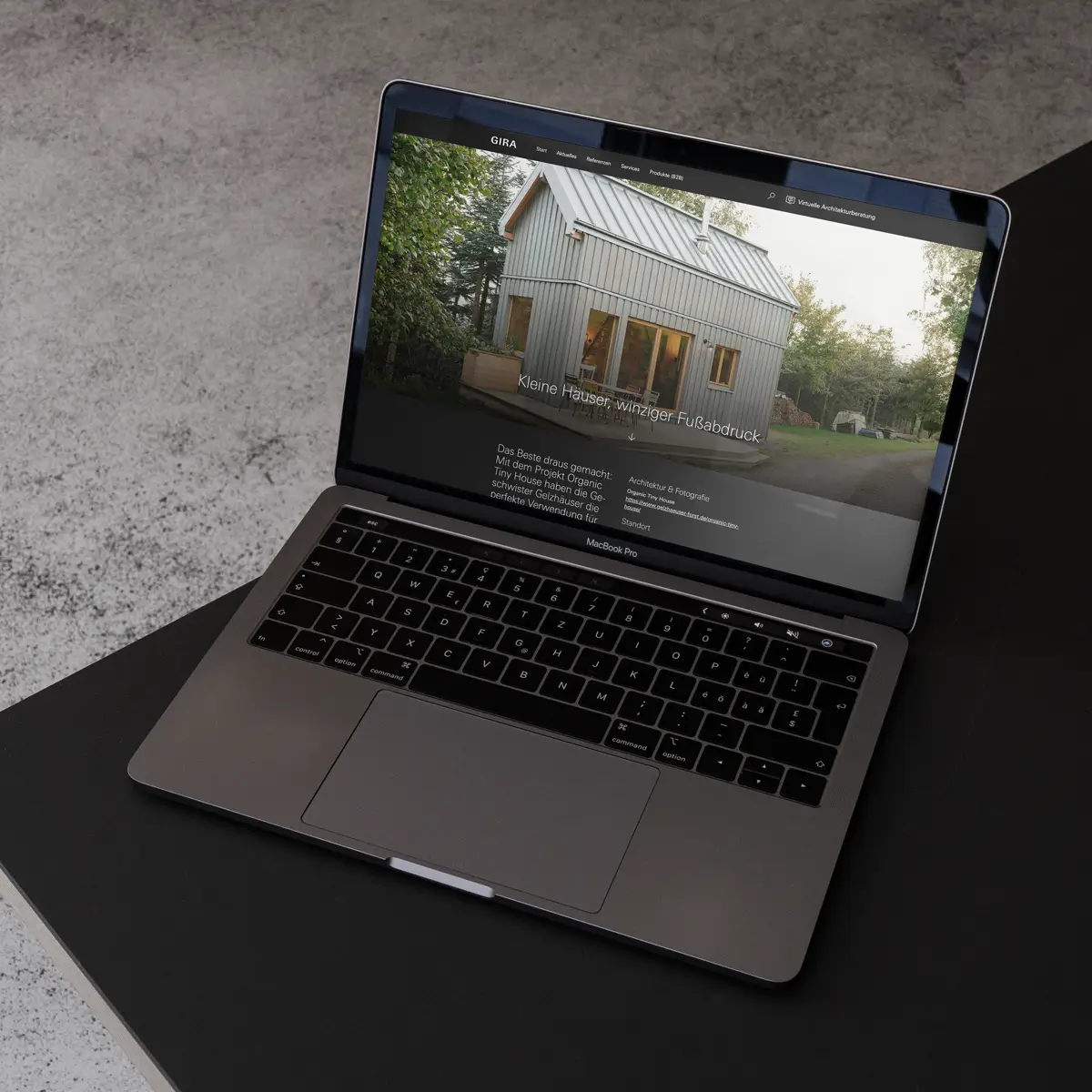 Gira-Website mit Tiny House-Referenz auf MacBook - Hersteller-Referenzkommunikation für Architekten
