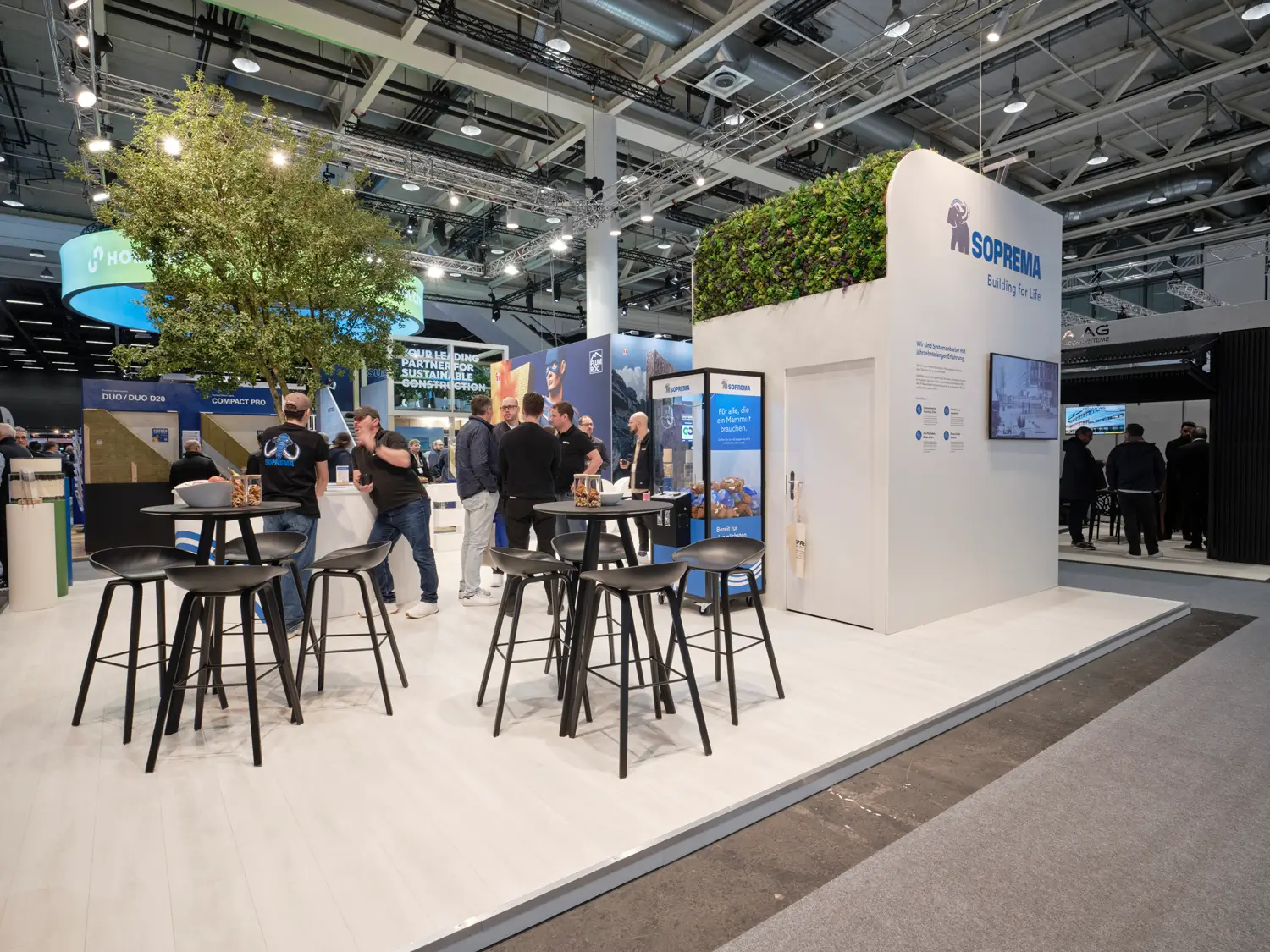 Beratungssituation am kompakten Inselstand von Soprema auf der Swissbau 2026.