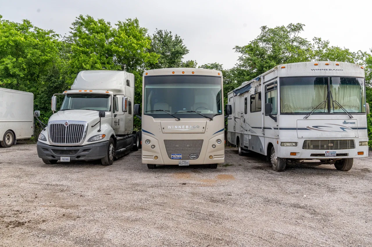 RV repair facility with multiple motorhomes and a heavy-duty truck parked for commercial service and maintenance.