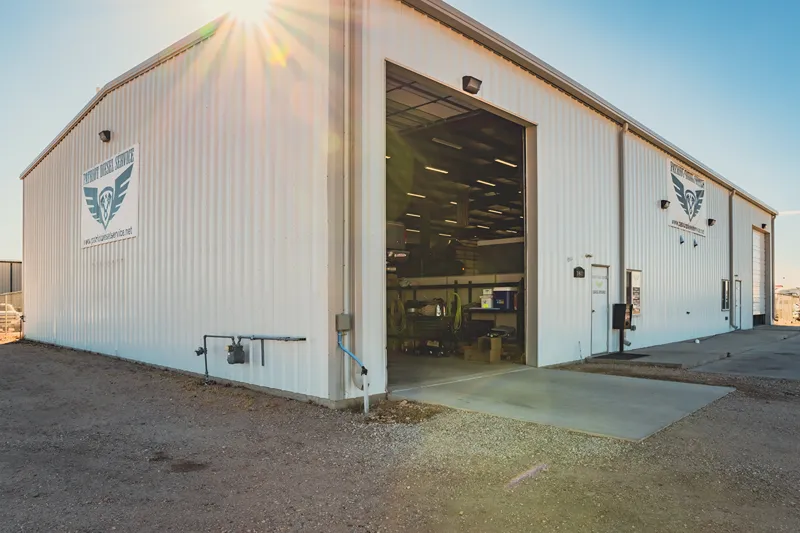 Cheyenne diesel repair shop with open service bay and fleet signage, hosting fleets for late-summer DPF and EGR service.