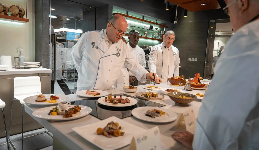 A group of chefs preparing food in a kitchen.