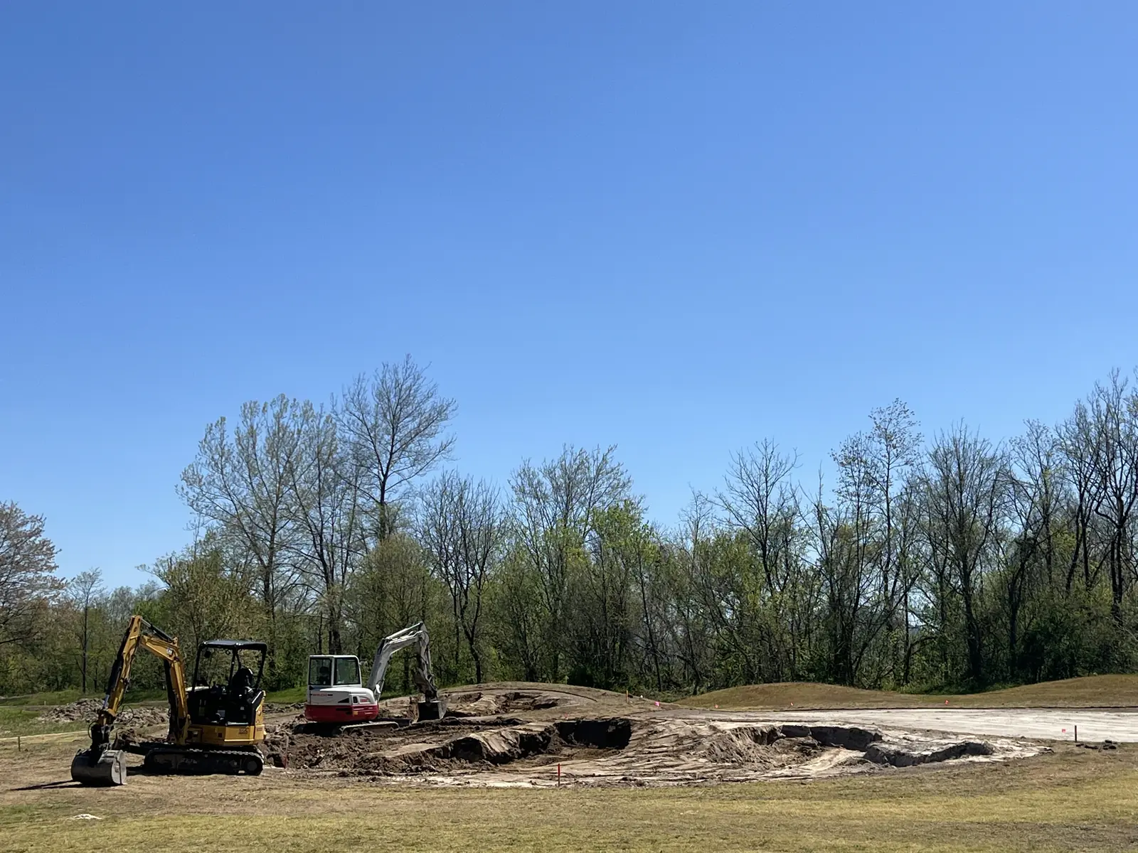 Excavators shaping a new bunker at the 16th green