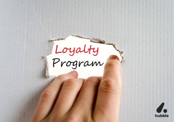 Hand revealing the words "Loyalty Program," symbolizing AI-driven advancements in customer retention strategies.