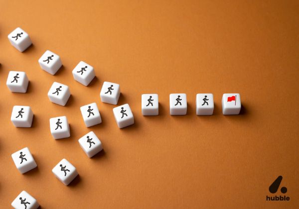 White dice with running icons forming a path toward a red flag, symbolizing goal achievement through gamification.