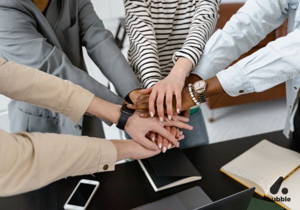 Team members stacking hands together, symbolizing collaboration and teamwork in experiential events.