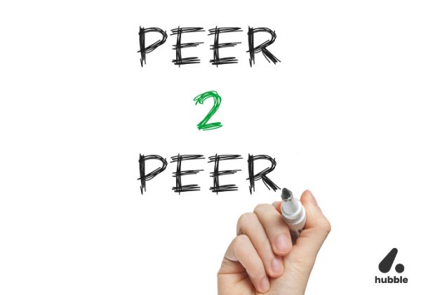 Hand writing "Peer 2 Peer" on a whiteboard, symbolizing peer-to-peer recognition in workplace culture.