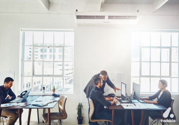 Modern office setting with employees collaborating, highlighting workplace motivation and employee recognition.