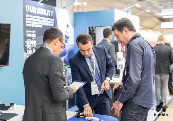 Business professionals engaging in a hands-on product demonstration at an event, representing experiential marketing trends