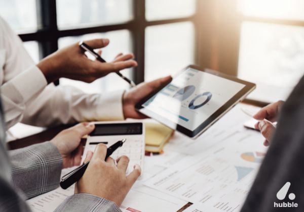 Business professionals analyzing charts on a tablet, discussing data and strategies for effective partner relationship management in channel sales.