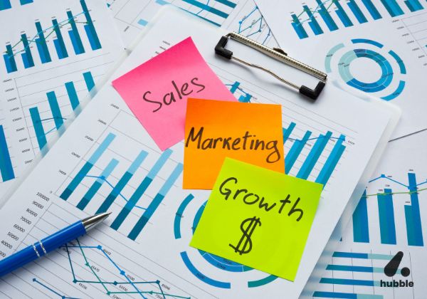 Sticky notes with "Sales," "Marketing," and "Growth" on charts, symbolizing behavioral nudges in marketing and sales